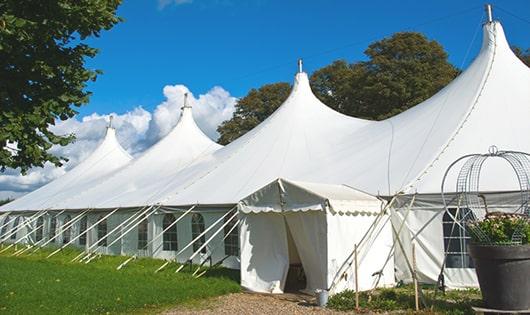 tall green portable restrooms assembled at a music festival, contributing to an organized and sanitary environment for guests in Mason